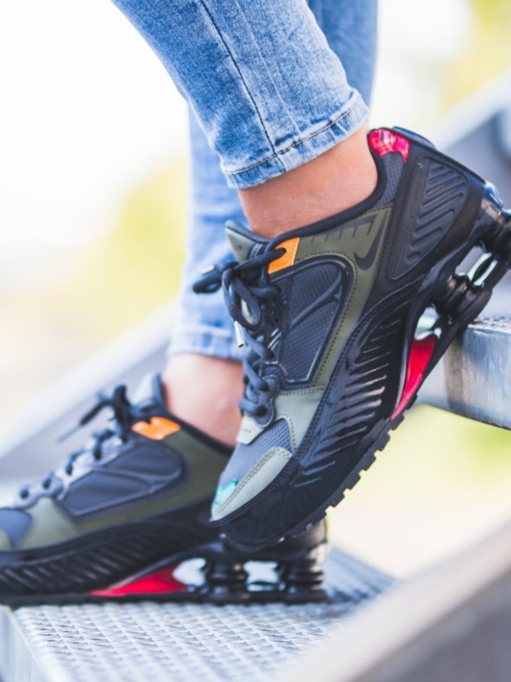 Nike Shox Enigma Black and Olive Athletic Sneakers with Orange and Red Accents.